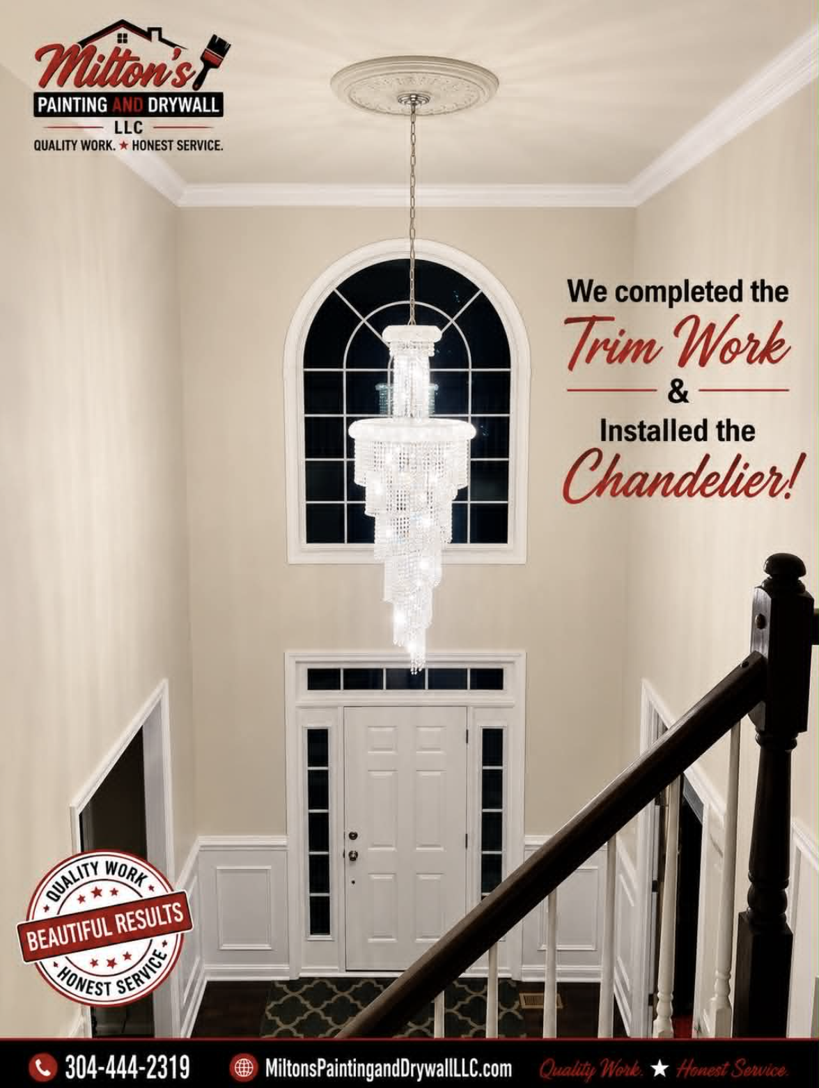 Finished two-story foyer with completed trim work and installed crystal chandelier.